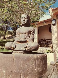 a statue sitting on a rock in front of a building at Apartment with pool in the mountains. in Alicante