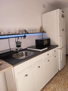 cocina con fregadero y nevera blanca en Apartment with pool in the mountains., en Alicante