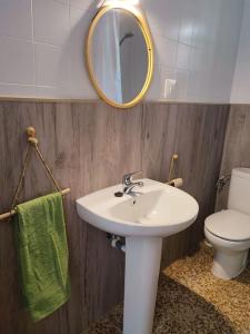 uma casa de banho com um lavatório, um WC e um espelho. em Apartment with pool in the mountains. em Alicante