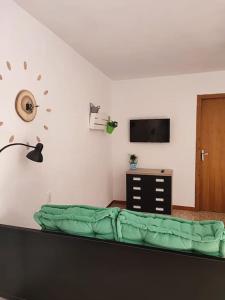 a living room with a couch and a tv and a wall at Apartment with pool in the mountains. in Alicante