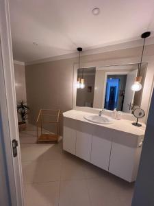 W łazience znajduje się umywalka i lustro. w obiekcie Cristinas 2 Bedroom Apartment Caniço w Caniço