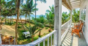 un porche con vistas al océano y a las palmeras en Kodi Beach Home, en Galle