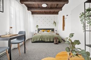 a bedroom with a bed and a desk and a table at Penzion Village Peace #29 by Goodnite cz - U Libušky in Brno