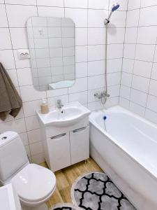 ein Badezimmer mit einem Waschbecken, einer Badewanne und einem WC in der Unterkunft Olive Home in Oral