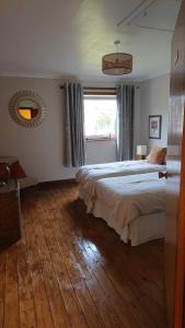 a bedroom with two beds and a large window at Strathspey in Kyleakin