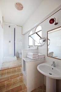 uma casa de banho branca com um lavatório e um espelho em Nido Verde em Agerola
