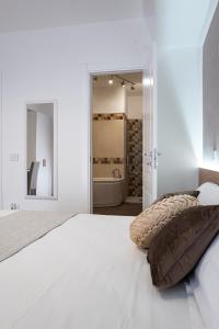 1 dormitorio blanco con 1 cama grande y baño en A Due Passi - Guest House, en Santo Stefano di Camastra