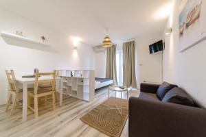 a living room with a couch and a dining room at Donata Apartments Zadar in Zadar
