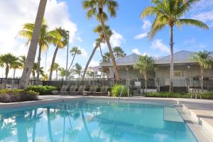 a swimming pool in front of a house with palm trees at The Perry Hotel & Marina Key West in Key West