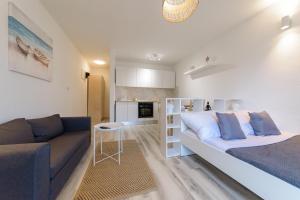 a bedroom with a large bed and a couch at Donata Apartments Zadar in Zadar