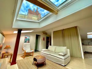 - un salon avec un plafond et une lucarne dans l'établissement Cosy flat in the city centre, à Toulouse