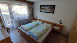Un dormitorio con una cama con almohadas. en Ciasa Rosada, en San Vigilio Di Marebbe