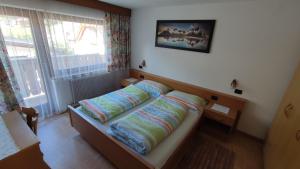 a bedroom with a bed with pillows on it at Ciasa Rosada in San Vigilio Di Marebbe