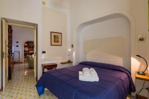 sypialnia z łóżkiem z dwoma ręcznikami w obiekcie Villa Paola - Hidden Panoramic Garden and Terraces by Napoliapartments w mieście Napoli