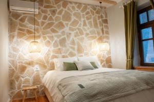 una camera da letto con un letto e una parete in pietra di locanta a Ioannina