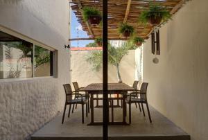 una mesa y sillas en un patio con plantas. en 5BR Beautiful home in downtown Cancun, 10min beach, en Cancún