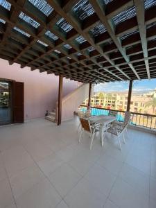een patio met een tafel en stoelen op een balkon bij Tala bay apartments 2 bedroom in Aqaba