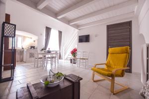 a living room with a yellow chair and a table at Masseria Casino Ciomme in Gioia del Colle