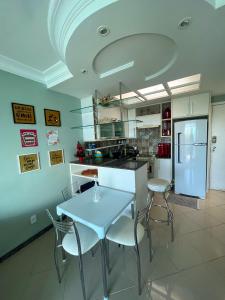 eine Küche mit einem Tisch und Stühlen sowie einem Kühlschrank in der Unterkunft Apartamento Porto Real Resort (11.1 402) com vista panorâmica in Angra dos Reis