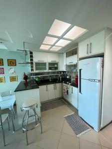 a kitchen with a refrigerator and a table and chairs at Apartamento Porto Real Resort (11.1 402) com vista panorâmica in Angra dos Reis