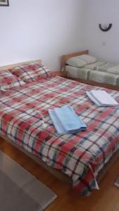 two beds in a room with a plaid blanket at Apartment Gajevi in Zlatibor