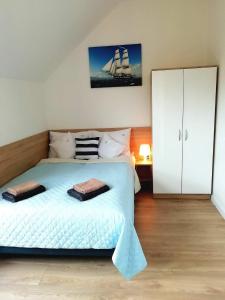 a bedroom with a large bed and a white cabinet at Promyki - Domki Apartamentowe in Chłopy