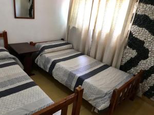 un grupo de 3 camas en una habitación en Departamento Pama en Santa Rosa de Calamuchita