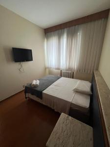 een slaapkamer met een bed en een flatscreen-tv bij Locking's Funcionários 4 in Belo Horizonte