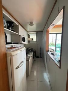 eine kleine Küche mit weißen Geräten und einem Fenster in der Unterkunft Locking's Funcionários 4 in Belo Horizonte