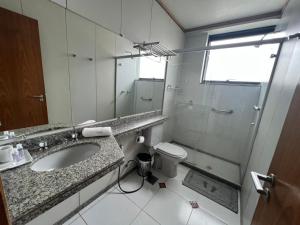 ein Bad mit einem Waschbecken, einer Dusche und einem WC in der Unterkunft Locking's Funcionários 4 in Belo Horizonte