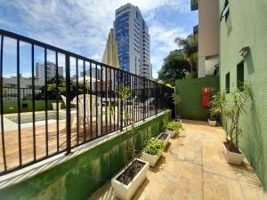een balkon met planten en een hek en een gebouw bij Locking's Funcionários 4 in Belo Horizonte