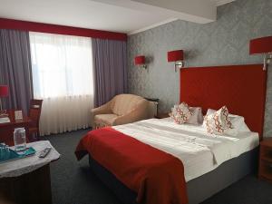 ein Hotelzimmer mit einem Bett und einem Stuhl in der Unterkunft Amigo Hotel in Sulejówek