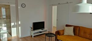 uma sala de estar com um sofá e uma televisão em Młynarska - słoneczne apartamenty em Piaseczno