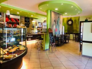 a restaurant with a counter and tables and chairs at Hotel Softwood in Recanati