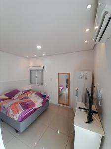 1 dormitorio con 1 cama y escritorio con ordenador en JK QUITINETES Executive GARAGEM central, en Pelotas