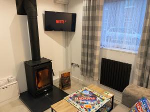 a living room with a stove in a room at Cardiff Coach House with Hot Tub & Log Fire in Cardiff