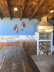 una cucina con stufa a legna e farfalle sul muro di Refugio Gaia a Chillán