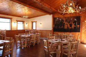 uma sala de jantar com mesas e cadeiras de madeira em Yellowstone Valley Inn em Wapiti