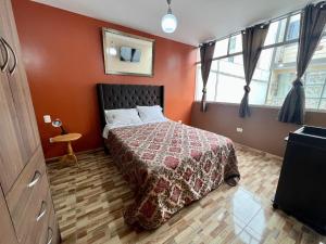 una camera con un letto con una parete rossa di TRUJILLO GUESTHOUSE a Víctor Larco Herrera