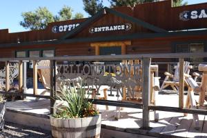 Yellowstone Valley Inn في وابيتي: كابينة خشب أمامها مجموعة كراسي
