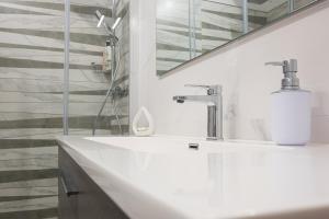 Baño blanco con lavabo y espejo en La Forgia - Guest House, en Santo Stefano di Camastra