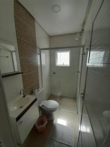 a bathroom with a toilet and a sink and a shower at JK POUSADA FLATS EXECUTIVE GARAGEM central in Pelotas +30 photos