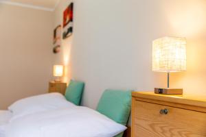 Un dormitorio con una cama y una lámpara en un tocador en Moderne Dachgeschosswohnung - Parkplatz - Netflix en Coburg