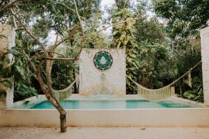 um portão no meio de uma piscina num jardim em Huaya Camp em Tulum
