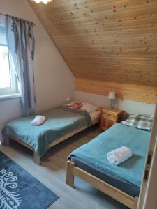 a bedroom with two beds and a wooden ceiling at Domek Jarmuta in Szlachtowa