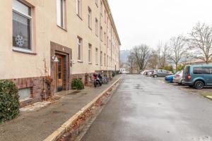 an empty street next to a building with parked cars at Moderne Dachgeschosswohnung - Parkplatz - Netflix in Coburg