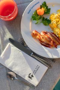 a plate of food with bacon and eggs on a table at Hotel Continental in Tortoreto Lido