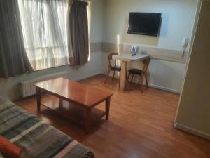 a living room with a table and a couch and a tv at Metro Pedro de Valdivia, Providencia. Departamento amplio 2 ambientes. in Santiago