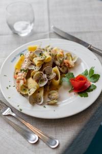a plate of food with shrimp and mushrooms on a table at Hotel Continental in Tortoreto Lido
