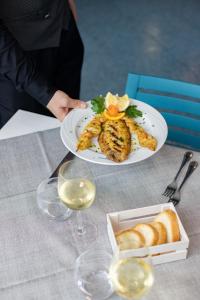 osoba trzymająca talerz jedzenia na stole w obiekcie Hotel Continental w mieście Tortoreto Lido